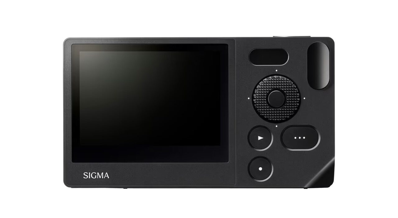 A grey mirrorless camera. Rectangle device with a large screen and some dials