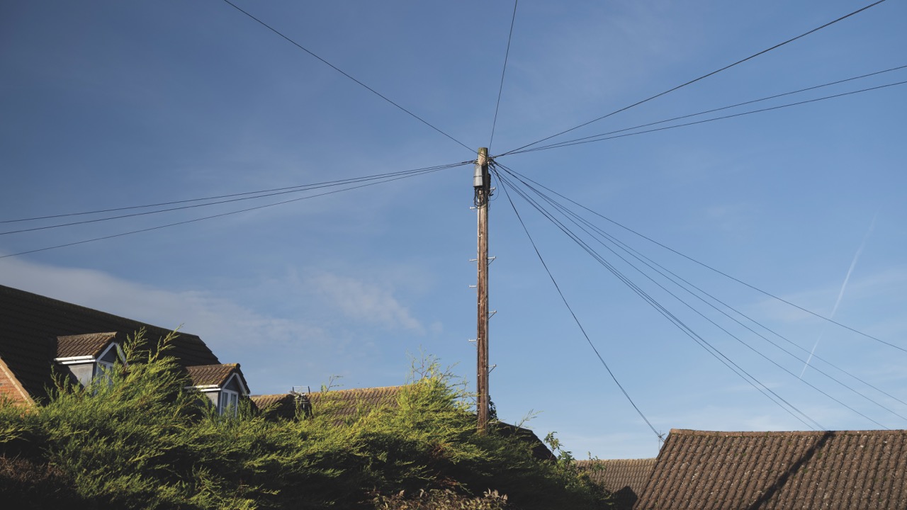 A phone mast in front of a blue sky with less saturation